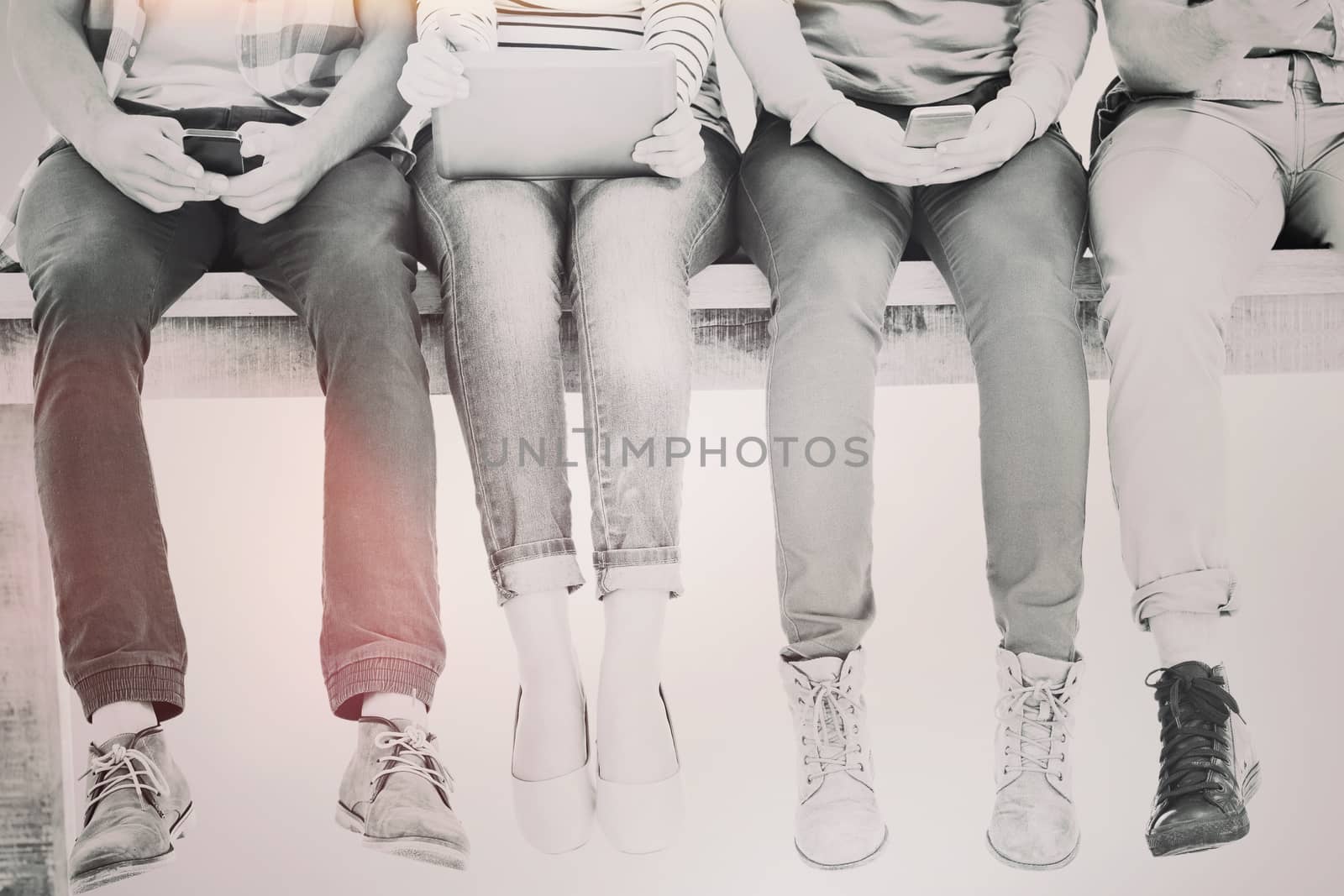 Low section of business people sitting on desk  against blue vignette background