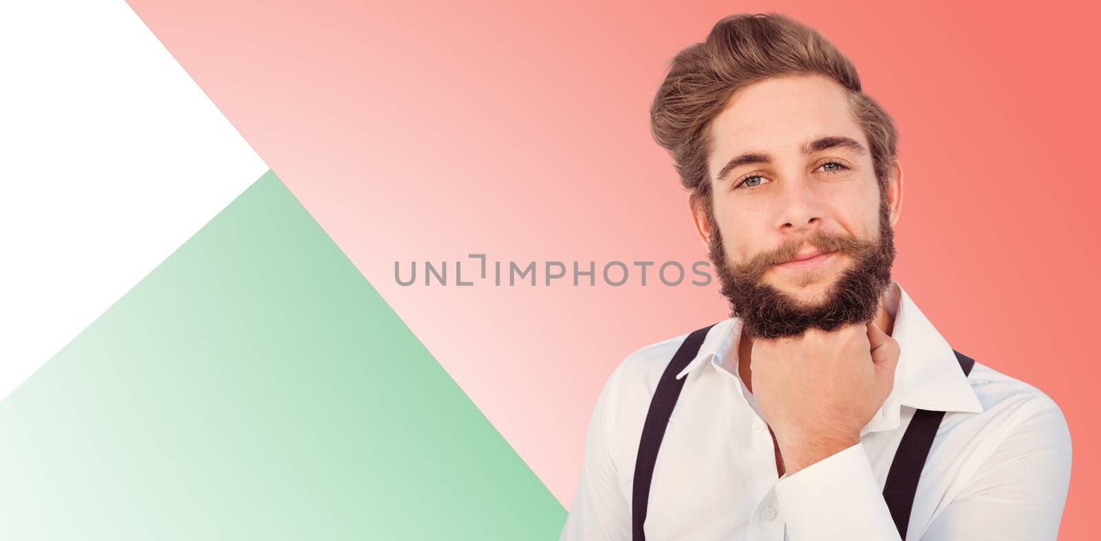 Confident hipster with hand on chin against green background