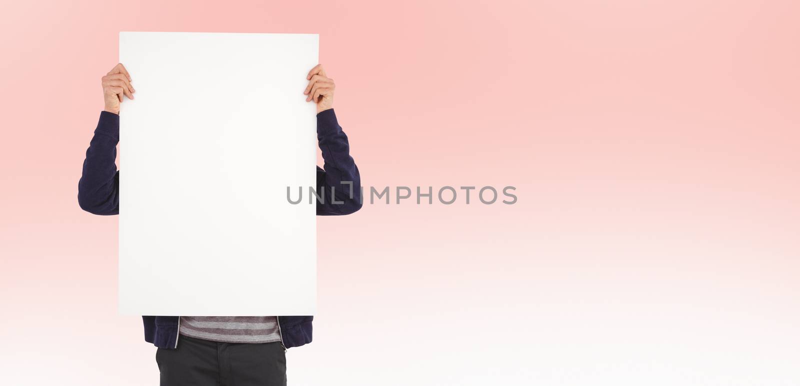 Man showing billboard in front of face against pastel pink