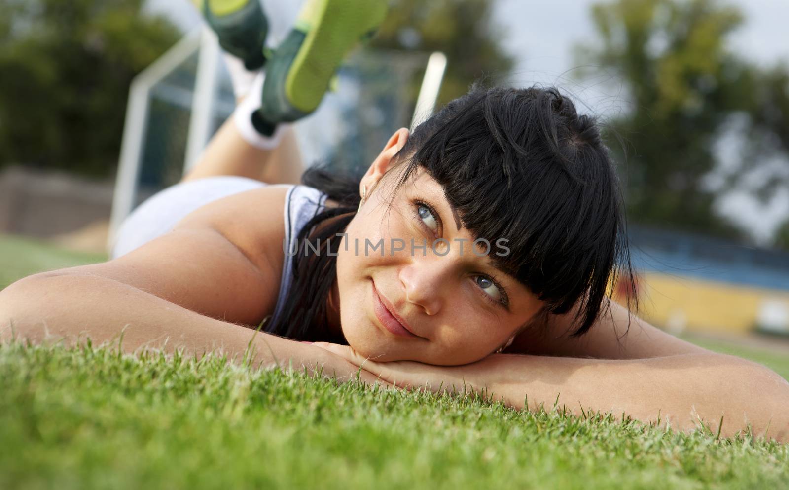 closeup of beautiful dreamy woman face that lies on grass