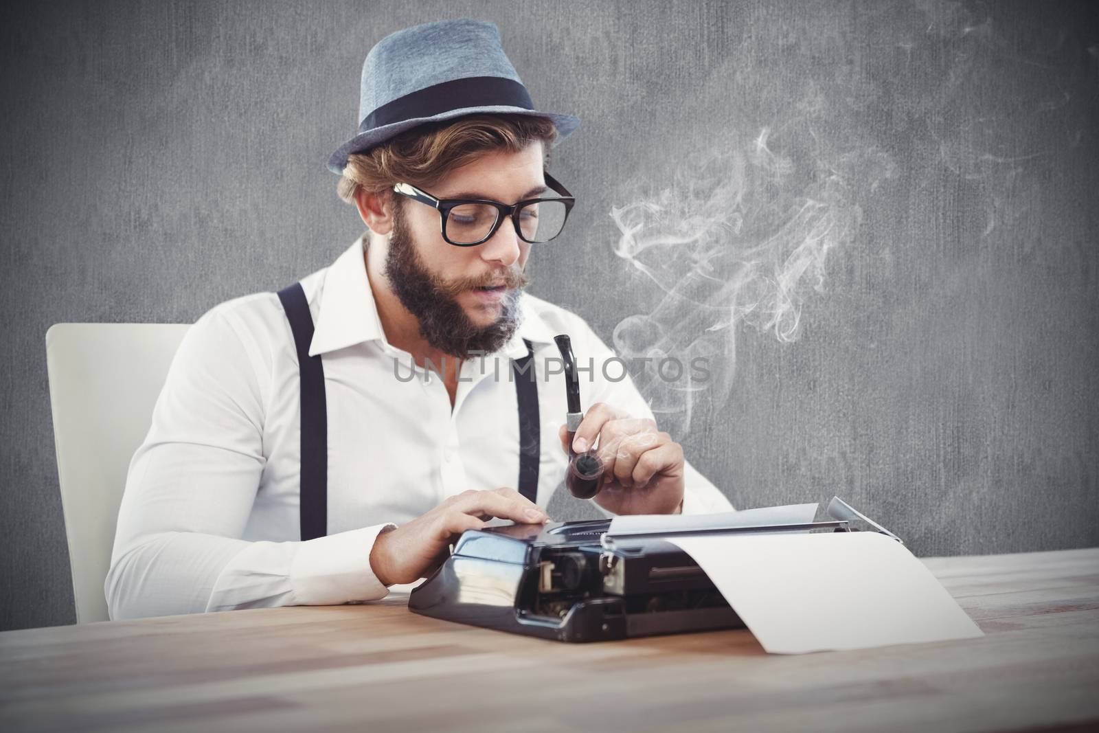 Hipster holding smoking pipe while working on typewriter against white and grey background