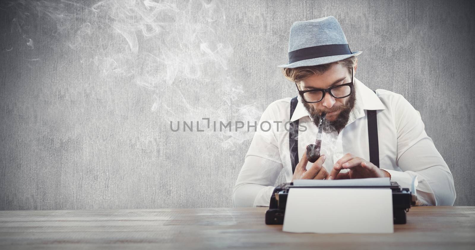 Composite image of hipster smoking pipe while working at desk by Wavebreakmedia