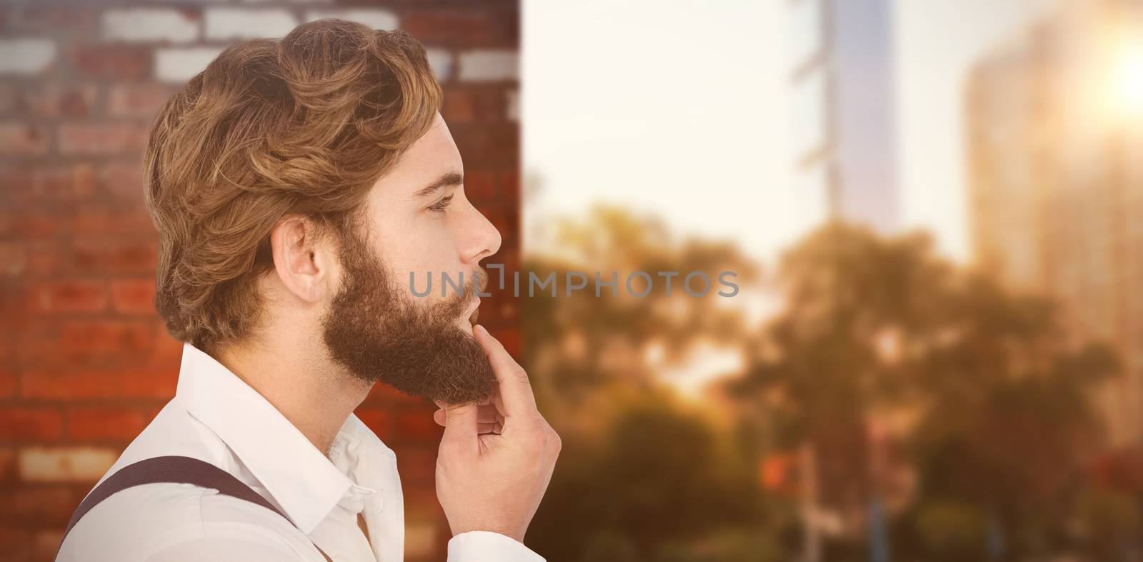 Profile view of hipster touching beard against wall of a house