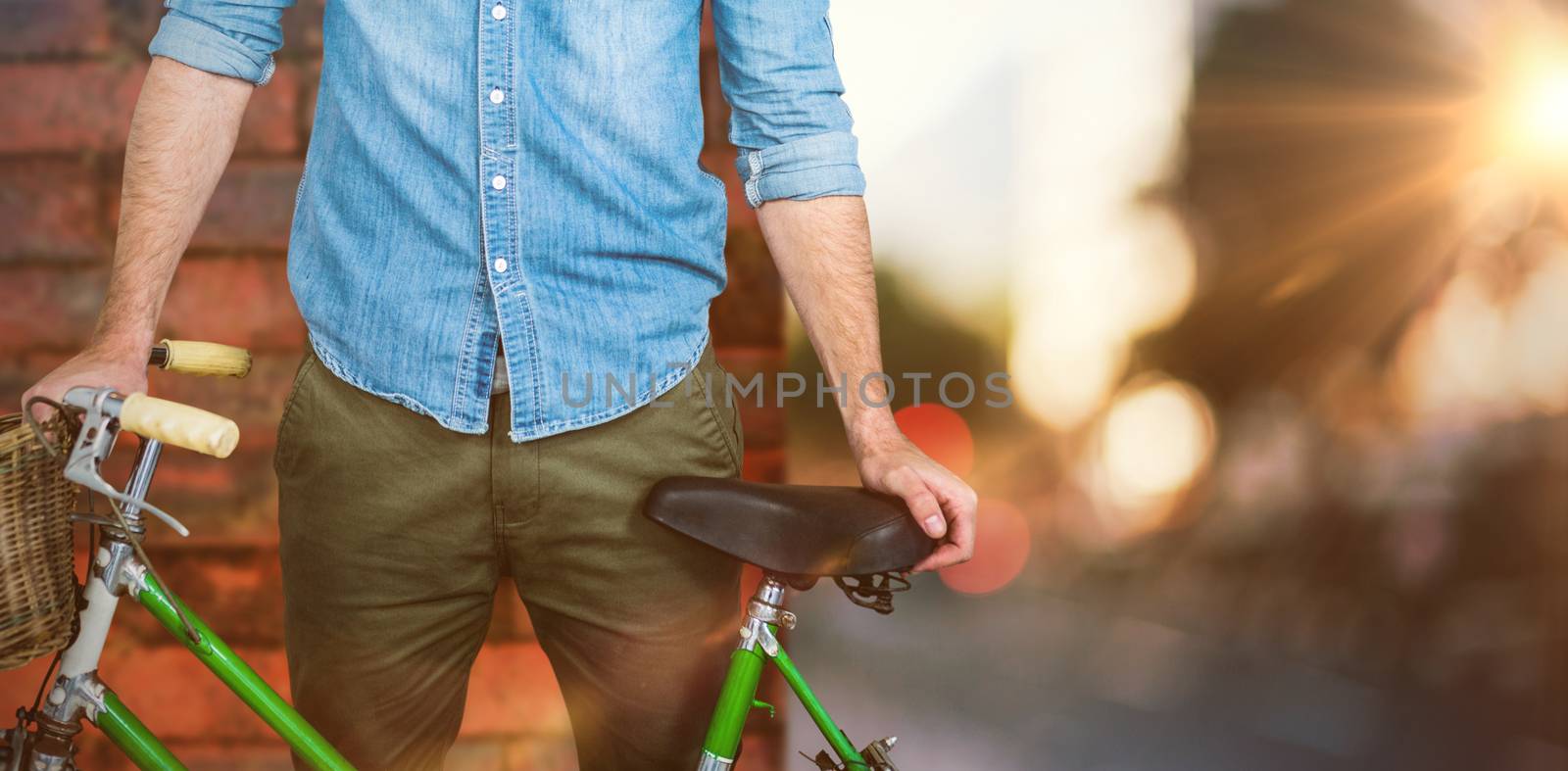 Portrait of hipster standing with bicycle against wall of a house