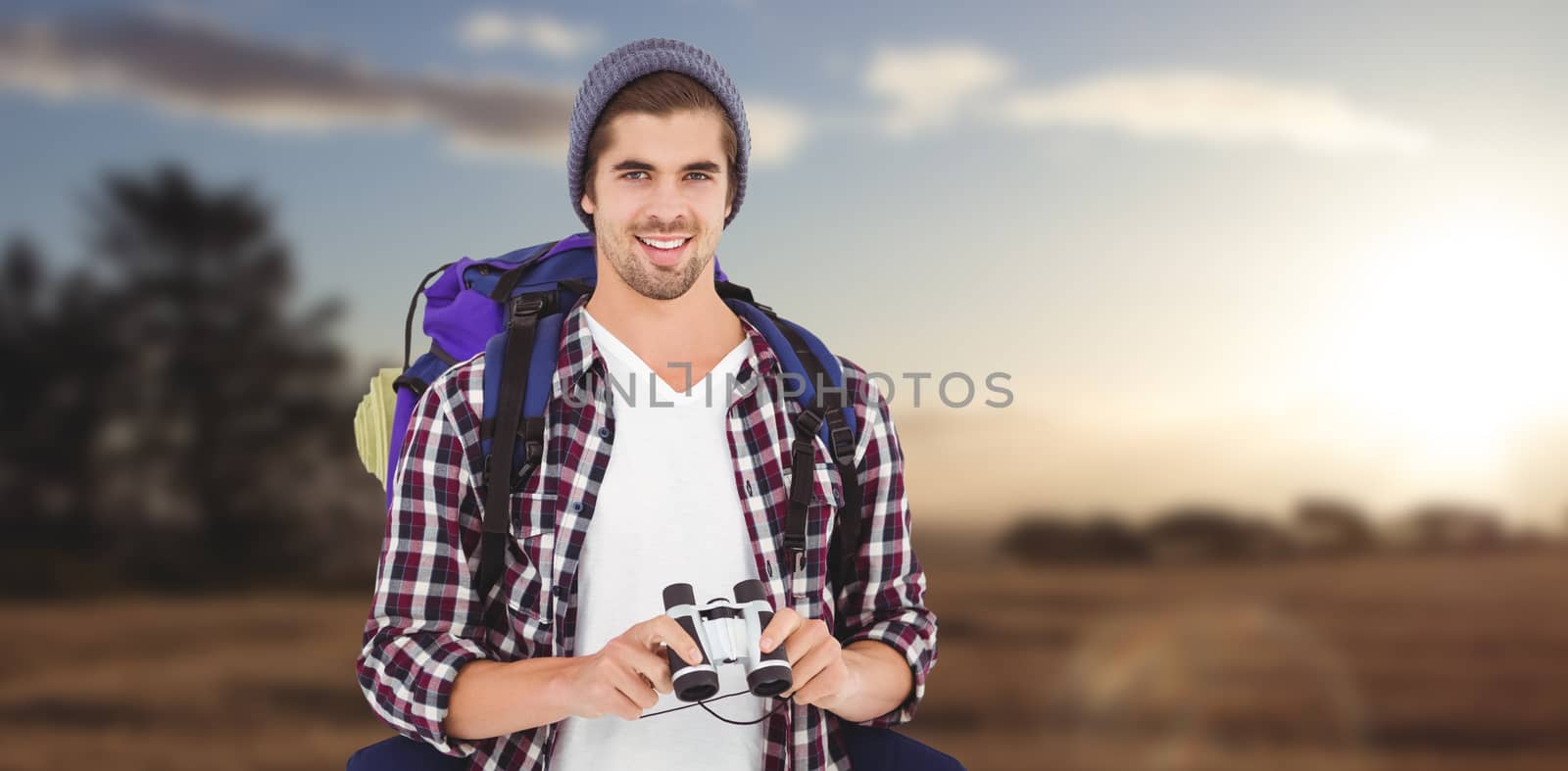 Composite image of happy hipster wearing backpack holding binoculars by Wavebreakmedia