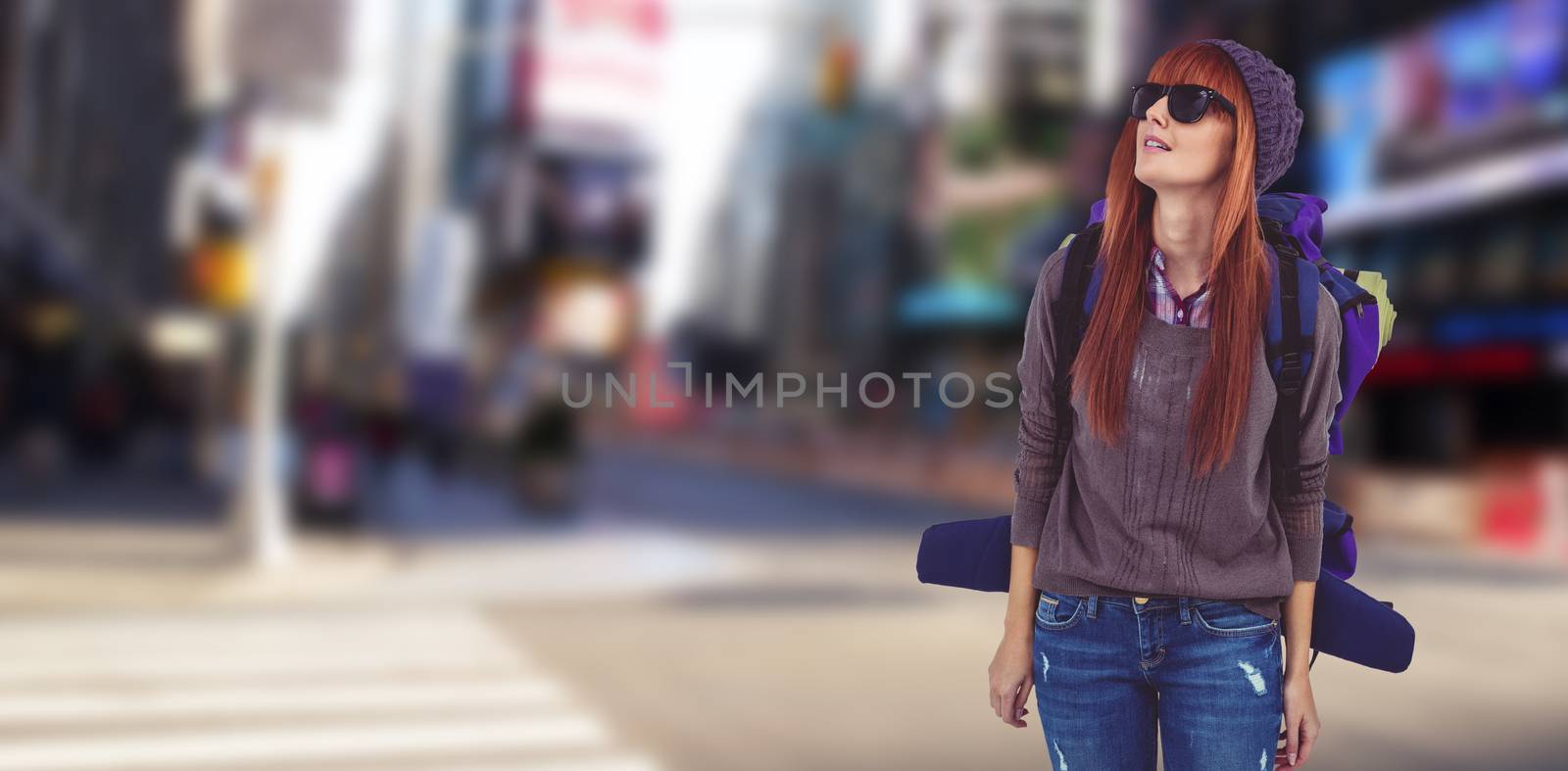 Portrait of a hipster woman with a travel bag against blurry new york street