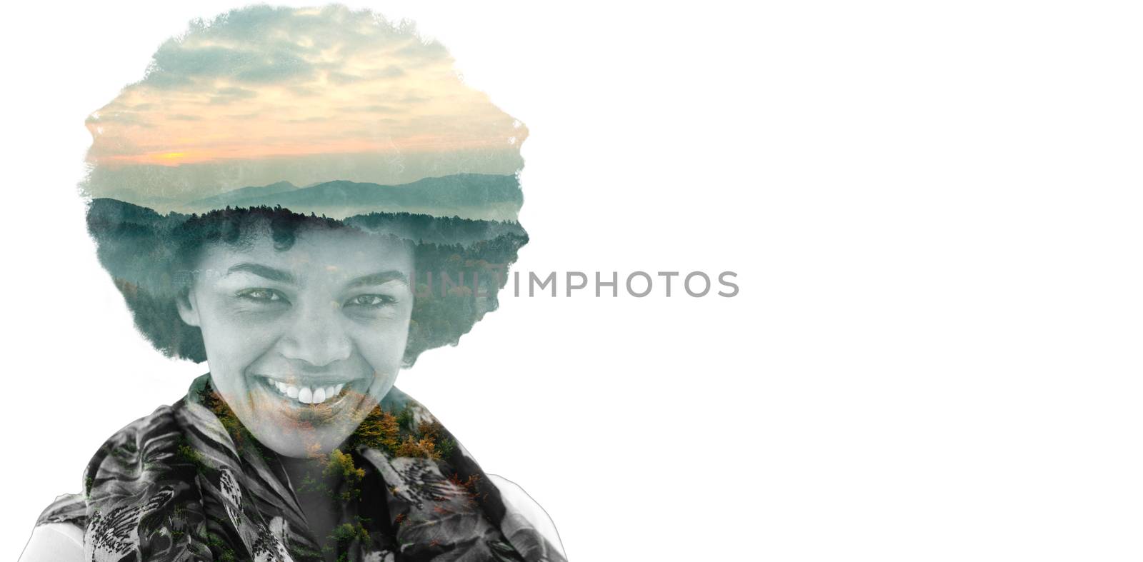 Brunette smiling to the camera against trees and mountain range against cloudy sky