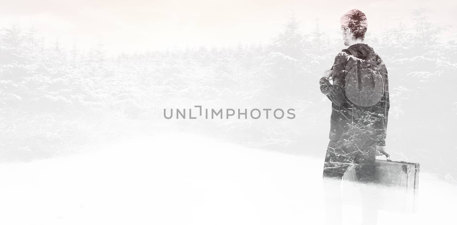 Rear view of man with backpack and briefcase against snow scene