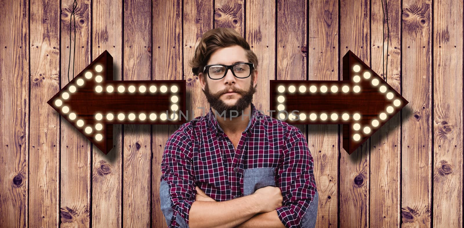 Confident hipster wearing eye glasses with arms crossed against wooden planks background
