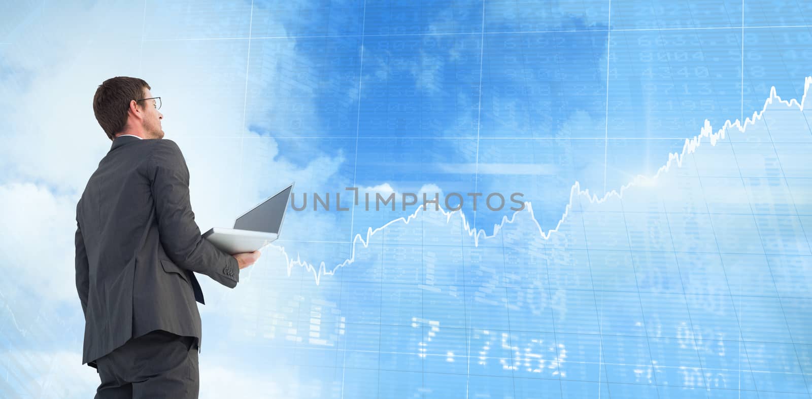 Composite image of businessman looking up holding laptop by Wavebreakmedia