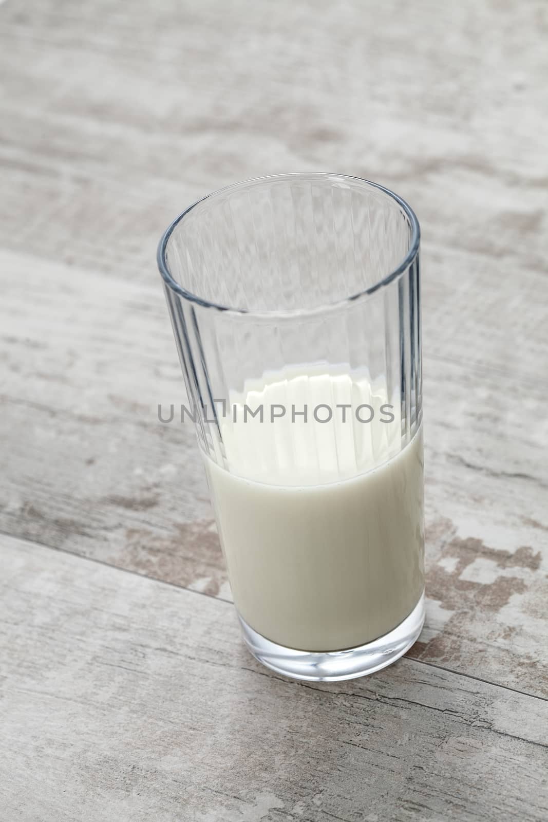 close up view of glass filled with fresh milk on wooden table