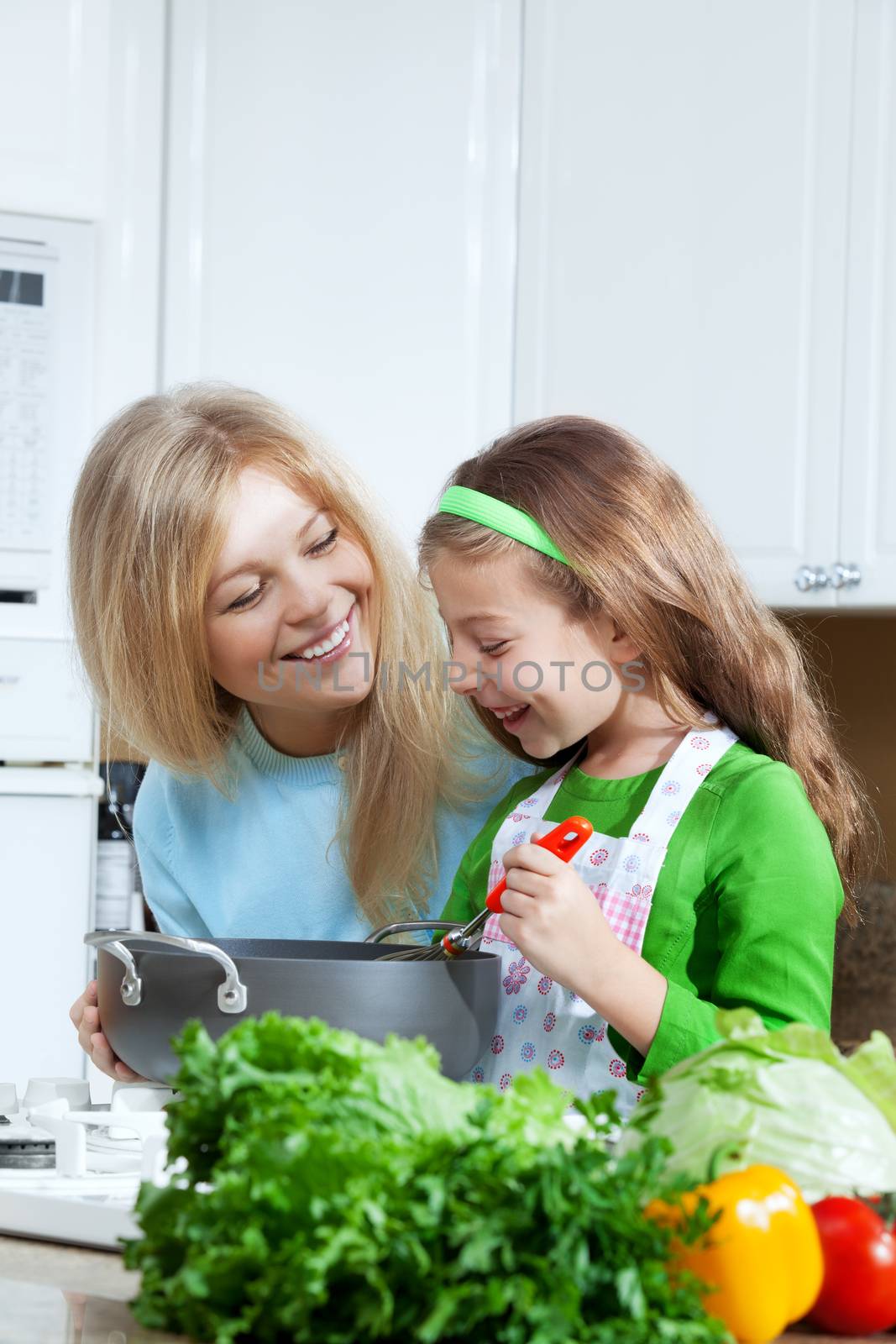 view of young beautiful girl cooking at the kitchen with her mama