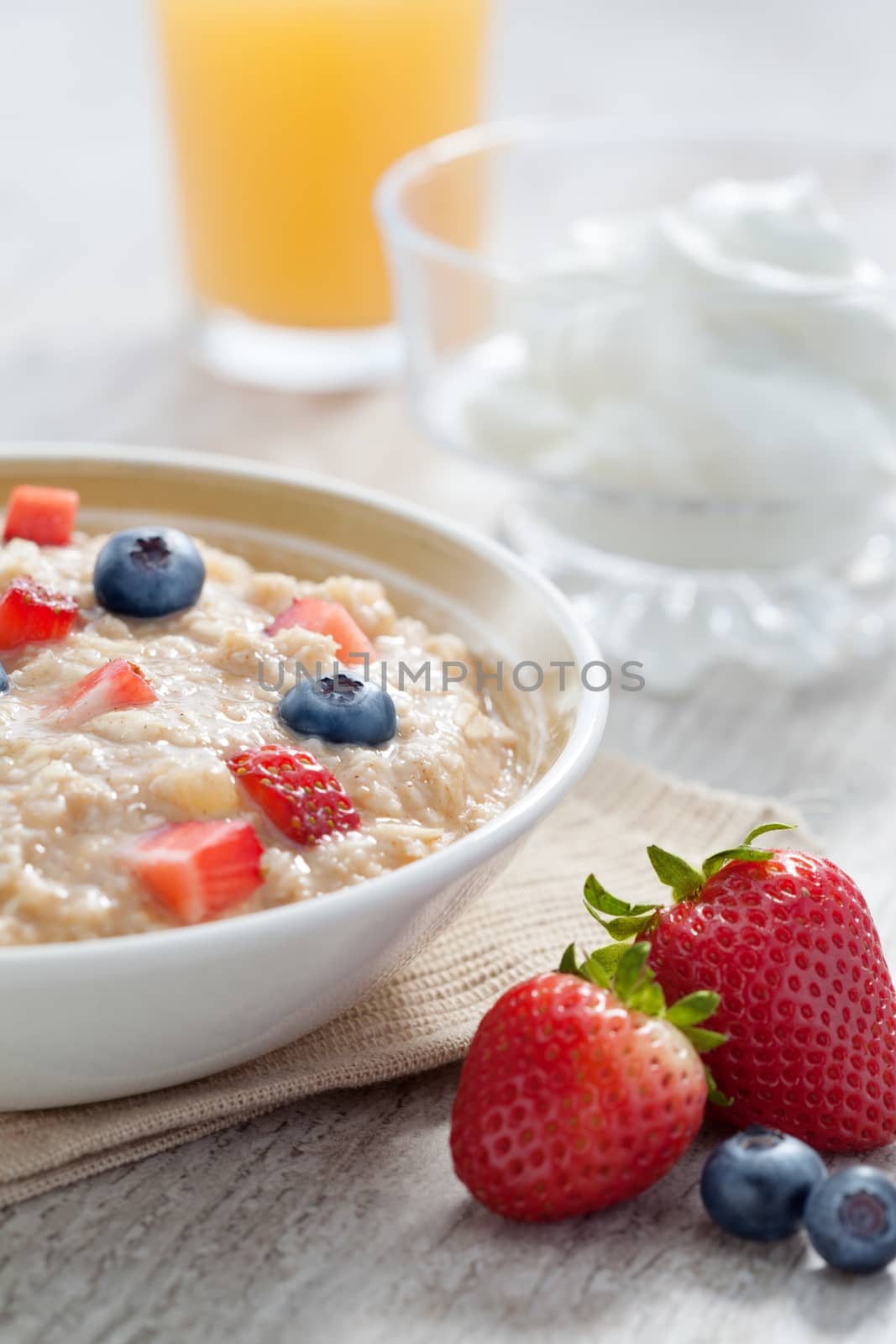 close up view of oatmeal porridge with strawberry on color back