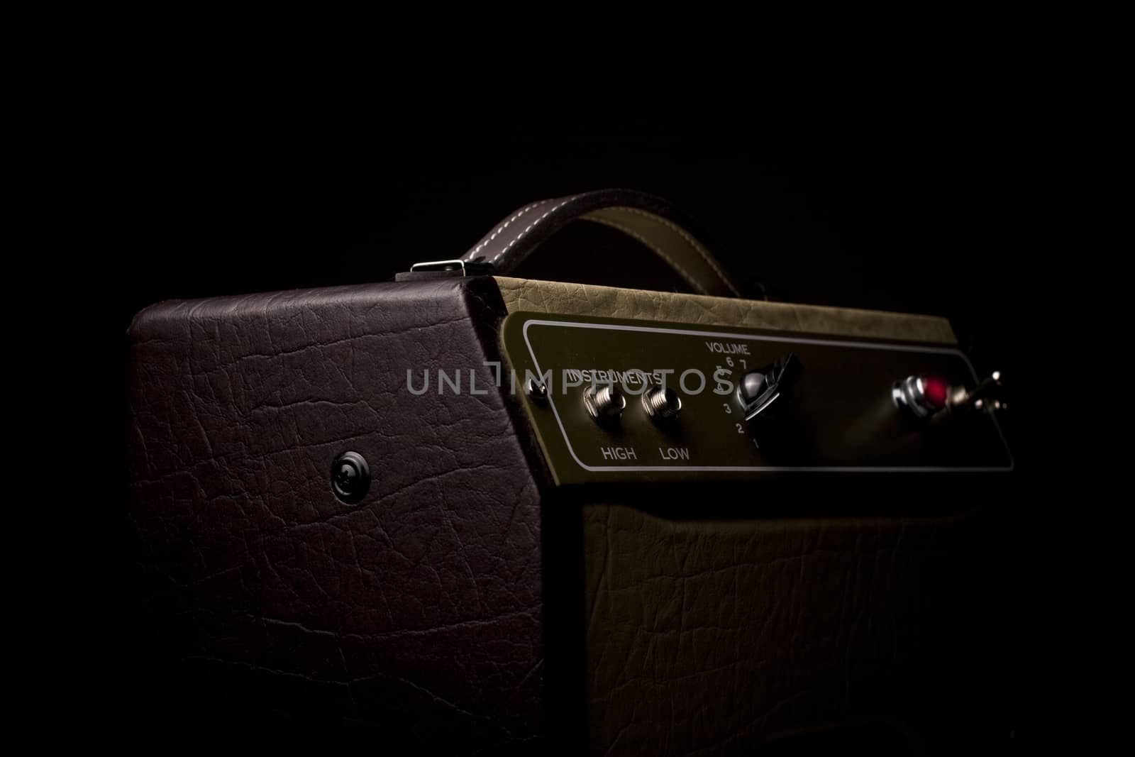 Horizotal picture of a leather finished guitar amplifier on black background viewed from the side