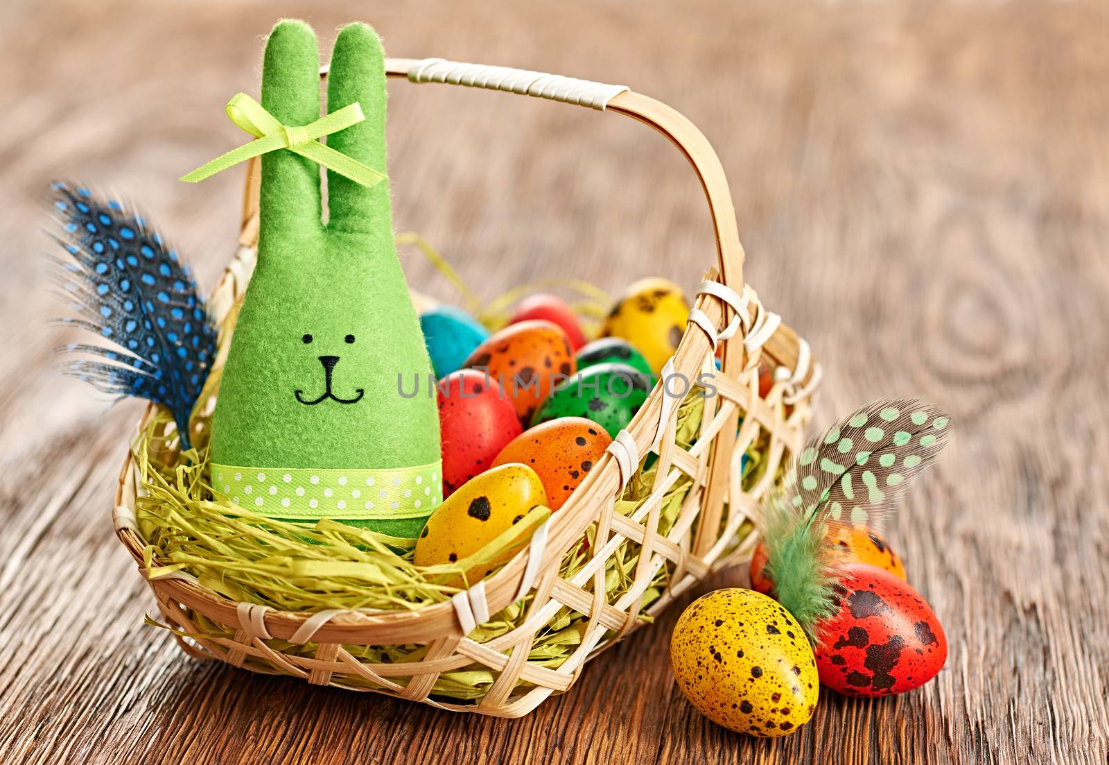Easter rabbit and painted eggs in basket on wood by 918