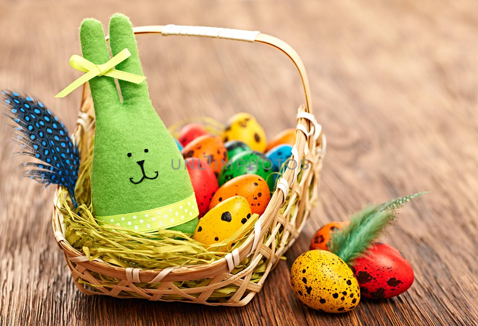 Easter rabbit and painted eggs in basket on wood by 918