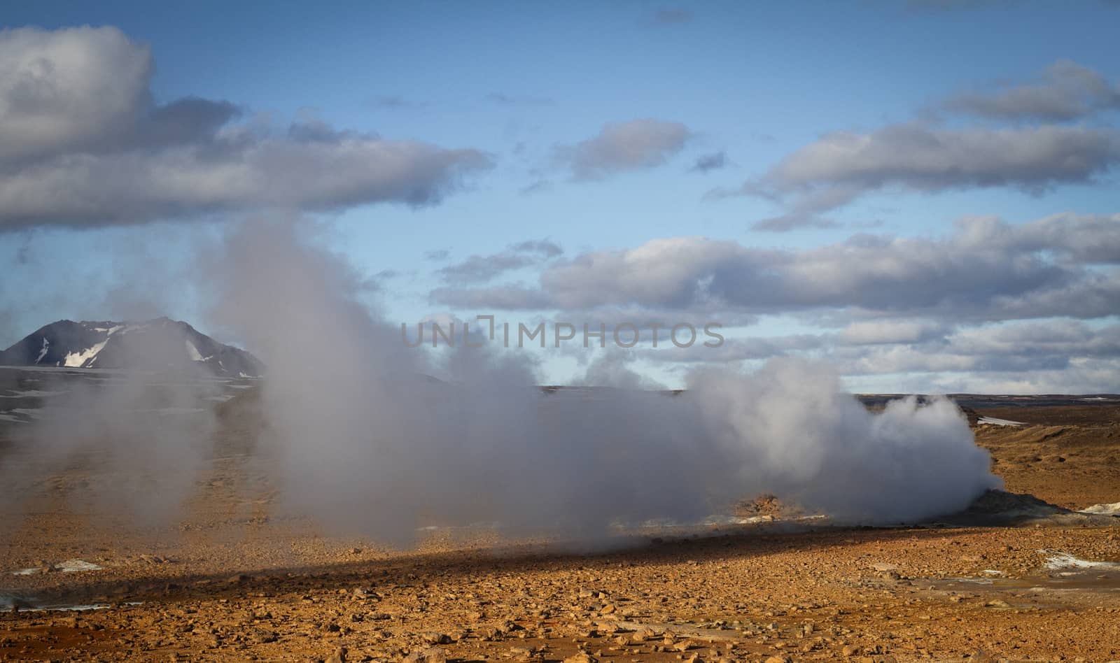 Horizontal view of steam hot springs coming out of the ground in the volcanic valley near Myvatn baths in Iceland