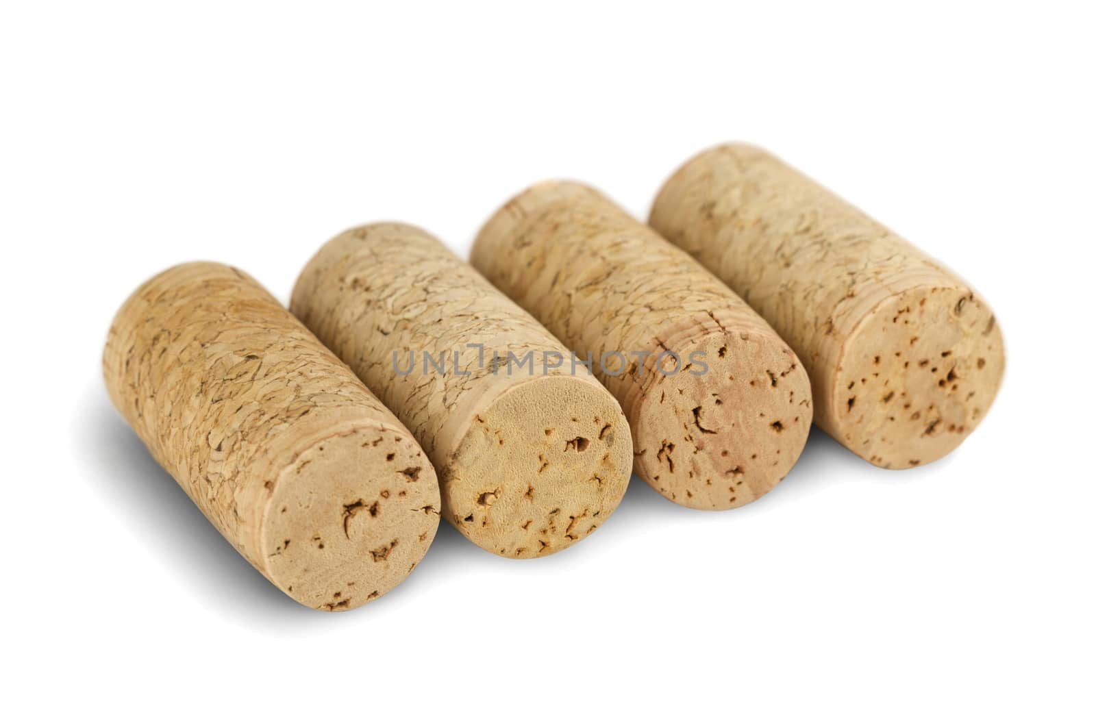 four wine corks arranged in a row, isolated on white background
