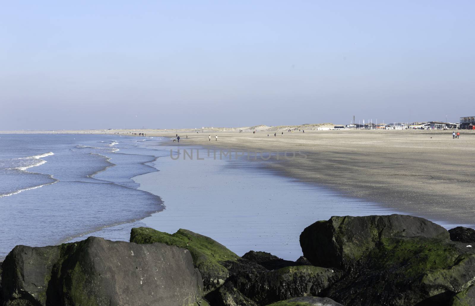 HOEK VAN HOLLAND,NETHERLANDS - FEBRUARI 17: Unidentified people walking on the beach near the sea on Februari 17 2016 in Hoek van Holland, this beach is the beach with the view on inccoming ships to Rotterdam harbour.