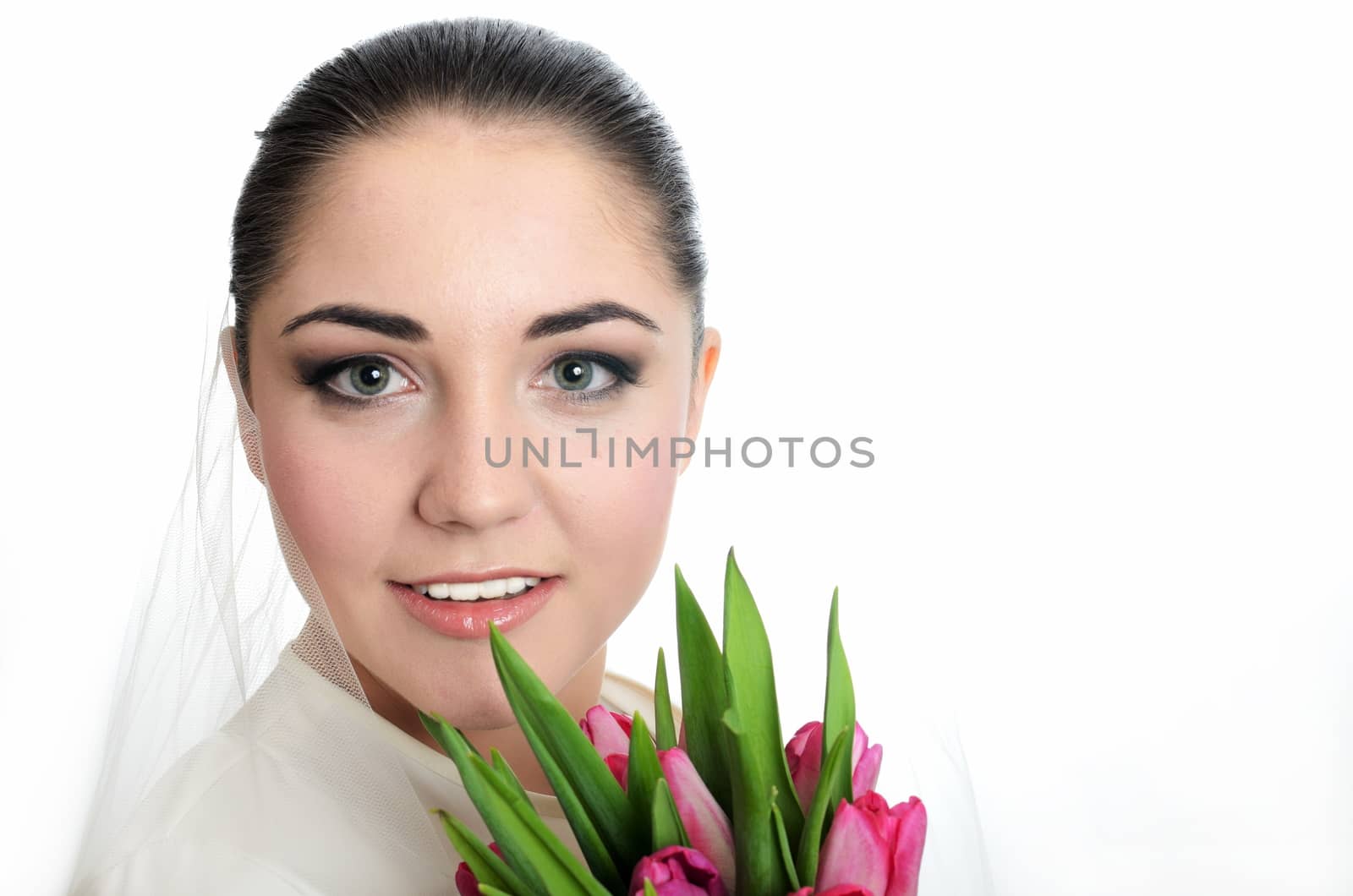 Happy bride with white veil and tulips bouquet in her hand. Young, happy female model.