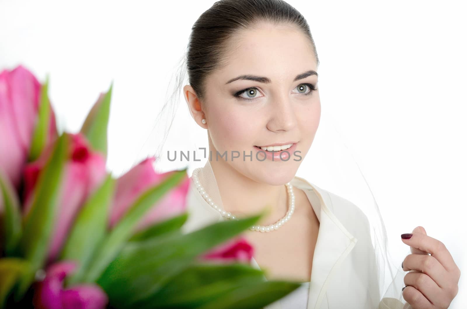 Tulips bouquet as foreground with female model as bride with white veil.