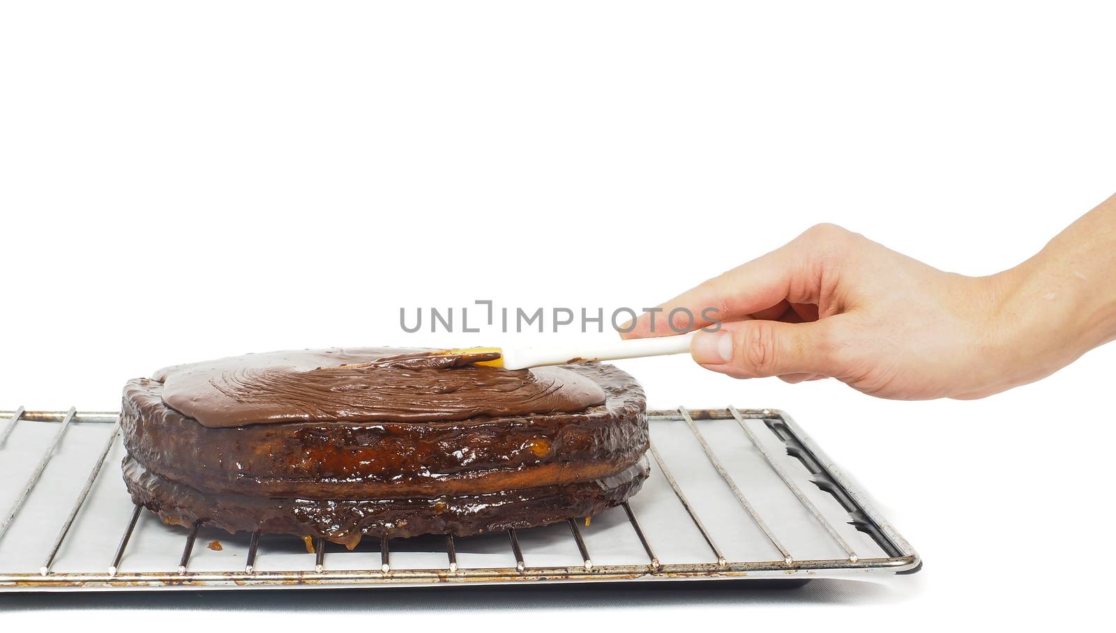 Pastry chef making final touches to a sacher chocolate cake with icing