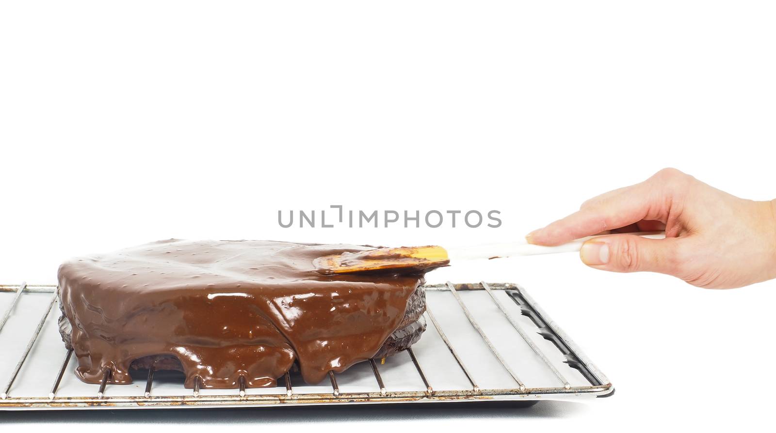 Pastry chef making final touches to a sacher chocolate cake with by Arvebettum