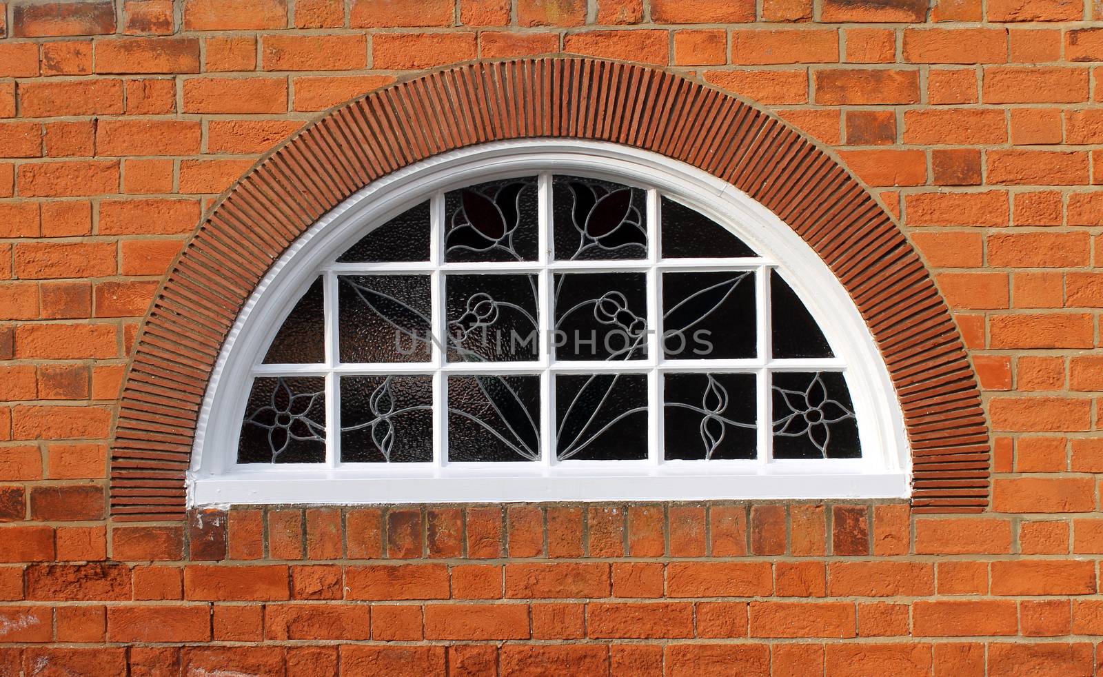 Exterior of a brick building with an arched window.