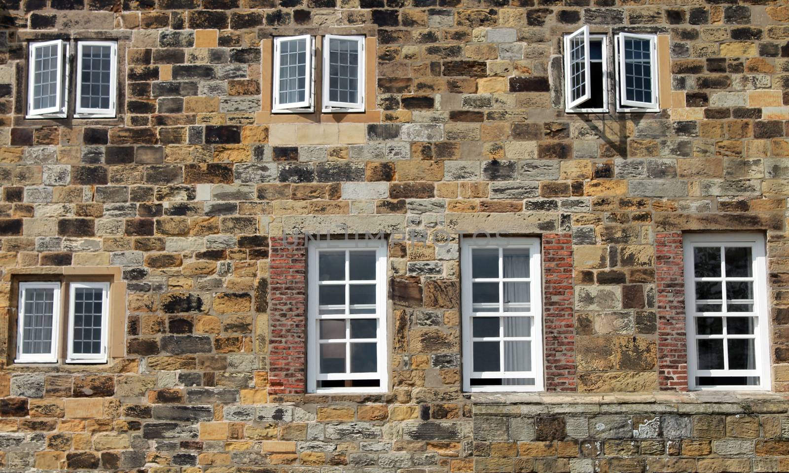 Exterior of a historic stone building with wooden framed windows.