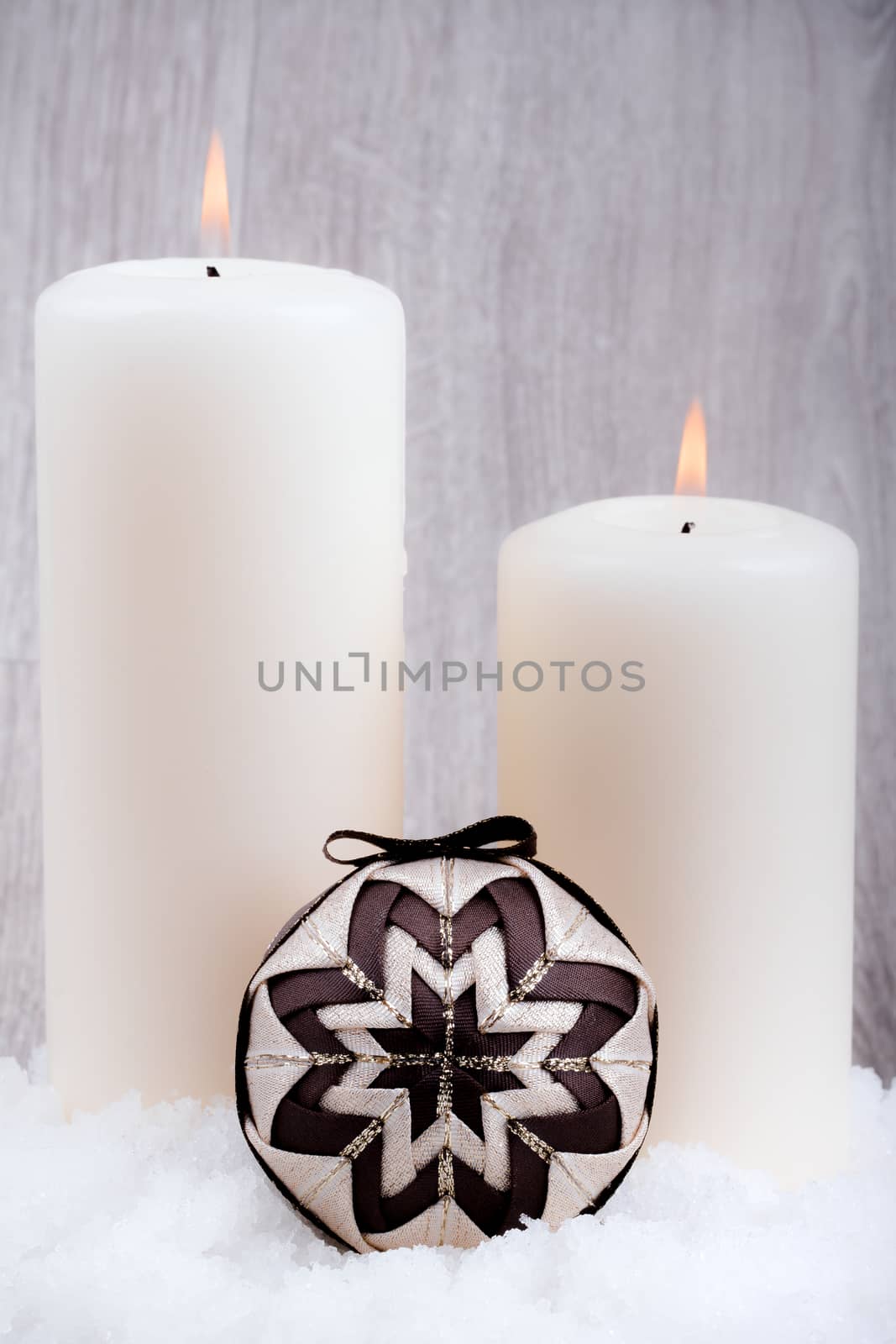 Two candles and christmas decoration on wooden background