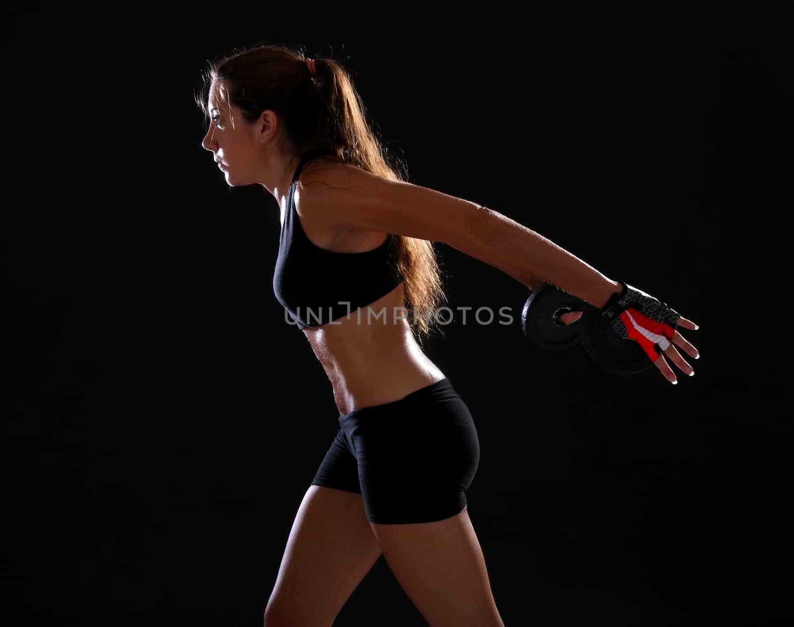 Young woman doing exercise with dumbbells by Erdosain