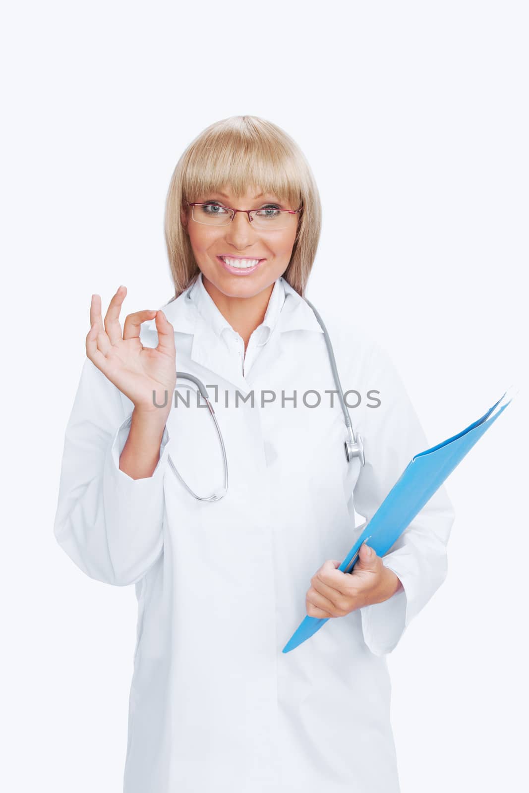 Portrait of nice doctor showing ok and smiling on white  back