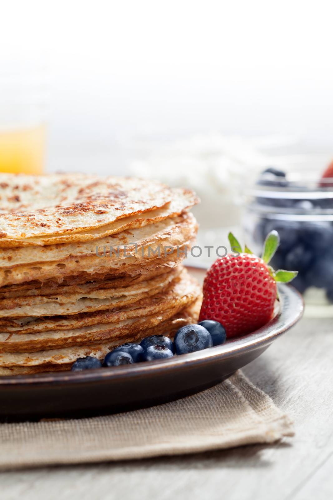 close up view of nice yummy crepes with berry on table