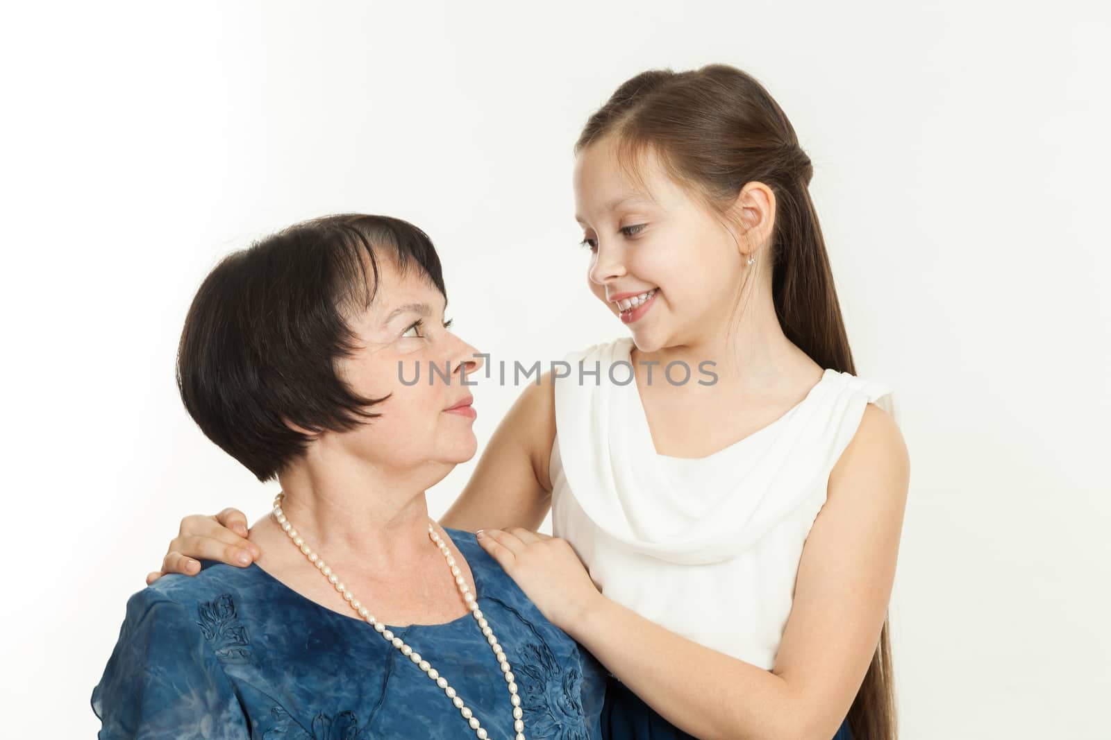 the grandmother and the granddaughter in dresses having embraced