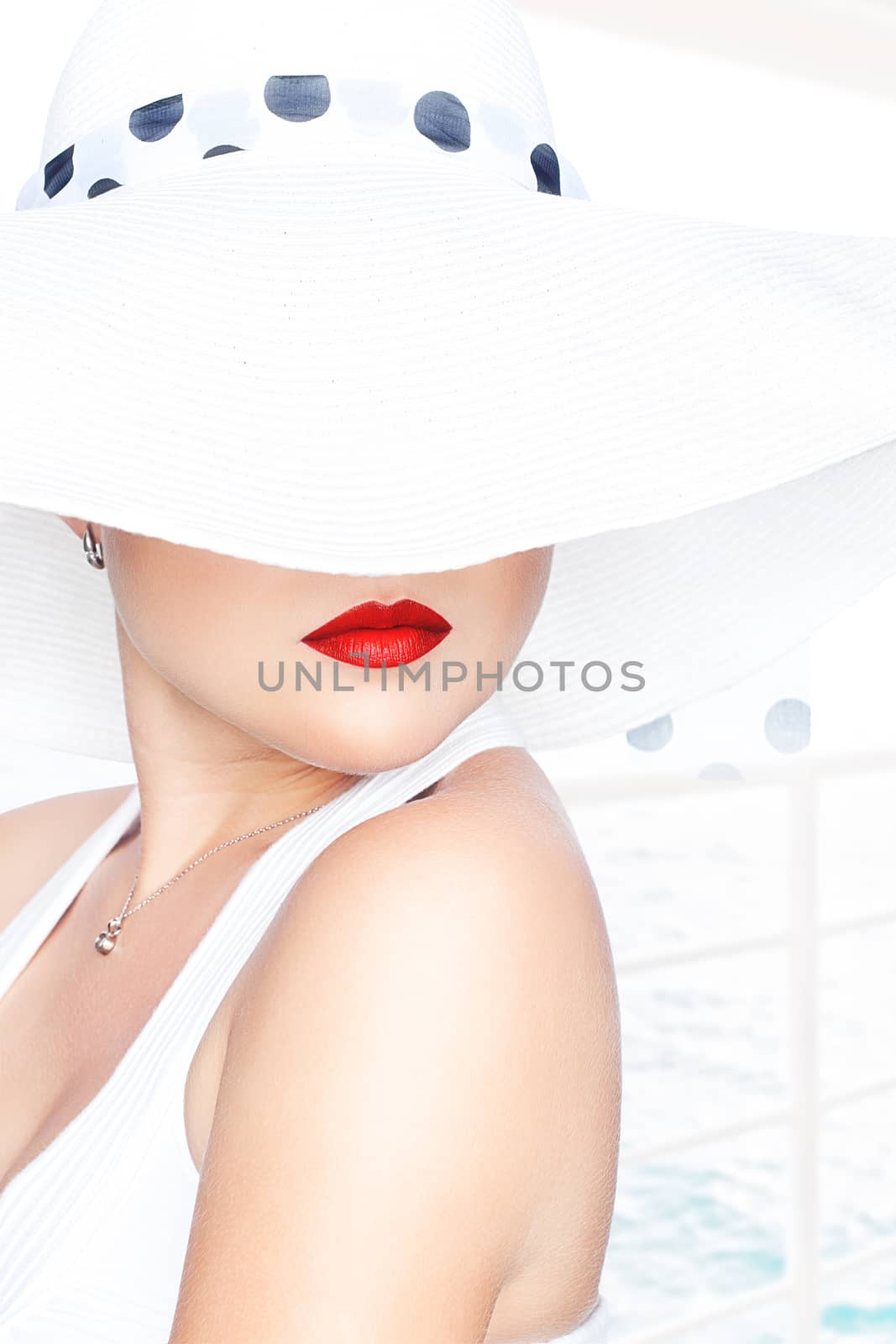 High key portrait of young beautiful woman  in white hat