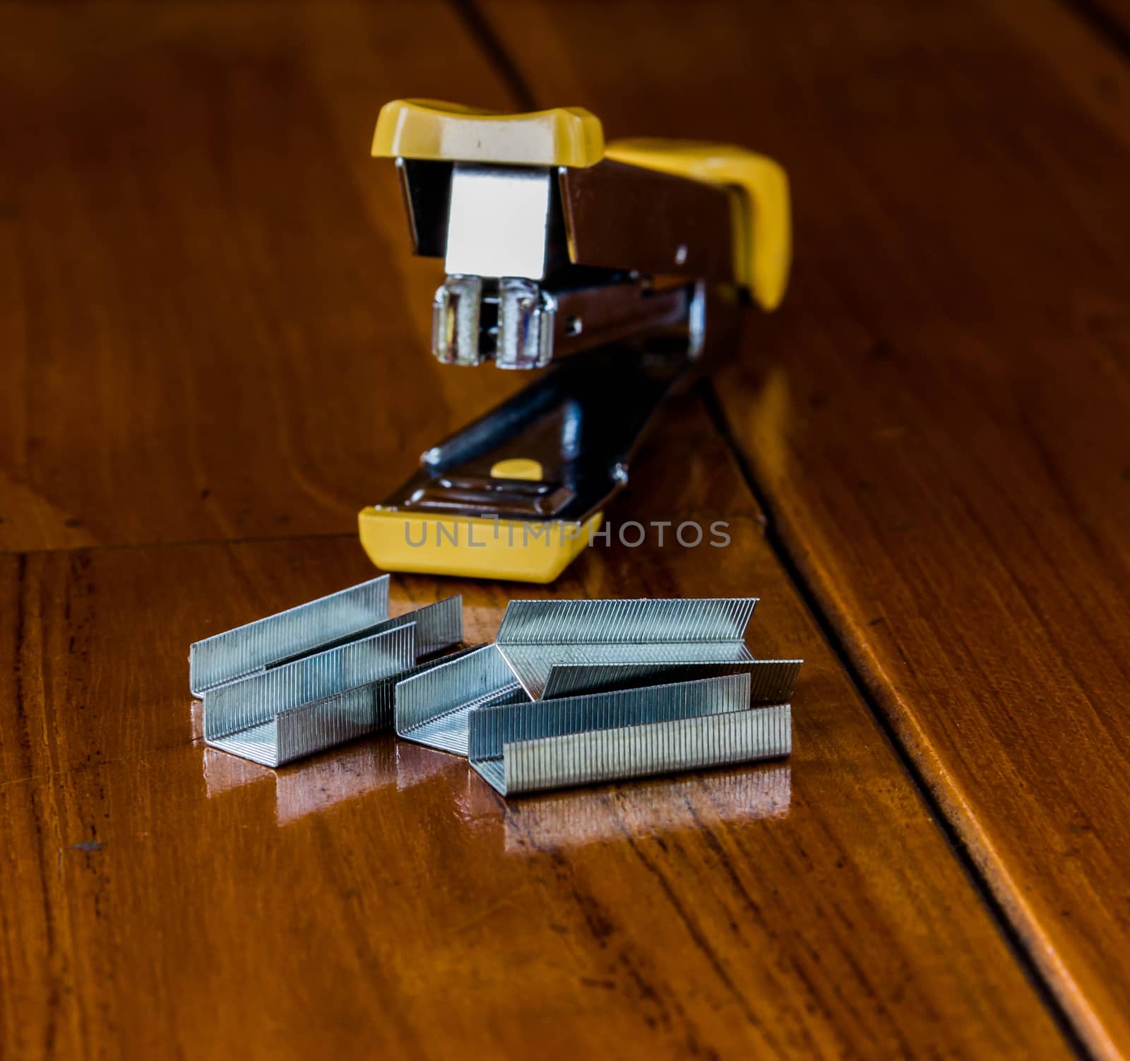 Stapler is on the wood.Focus on an object in the foreground of the picture.