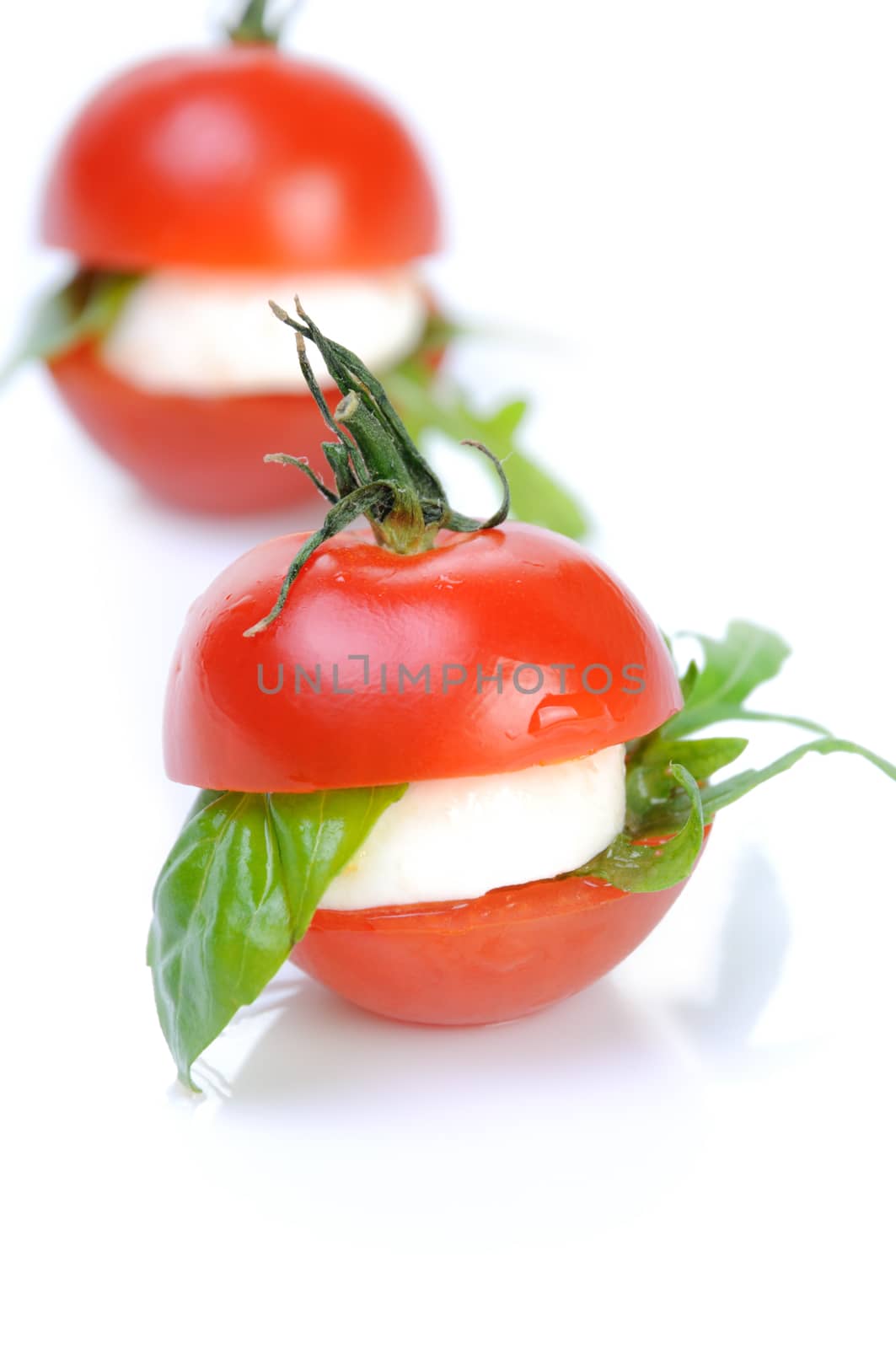 Appetizer cherry tomato with mozzarella and basil, arugula