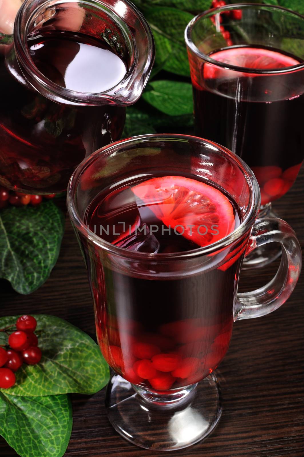 A glass of hot low-alcohol drink made from honey, cranberries, lemon