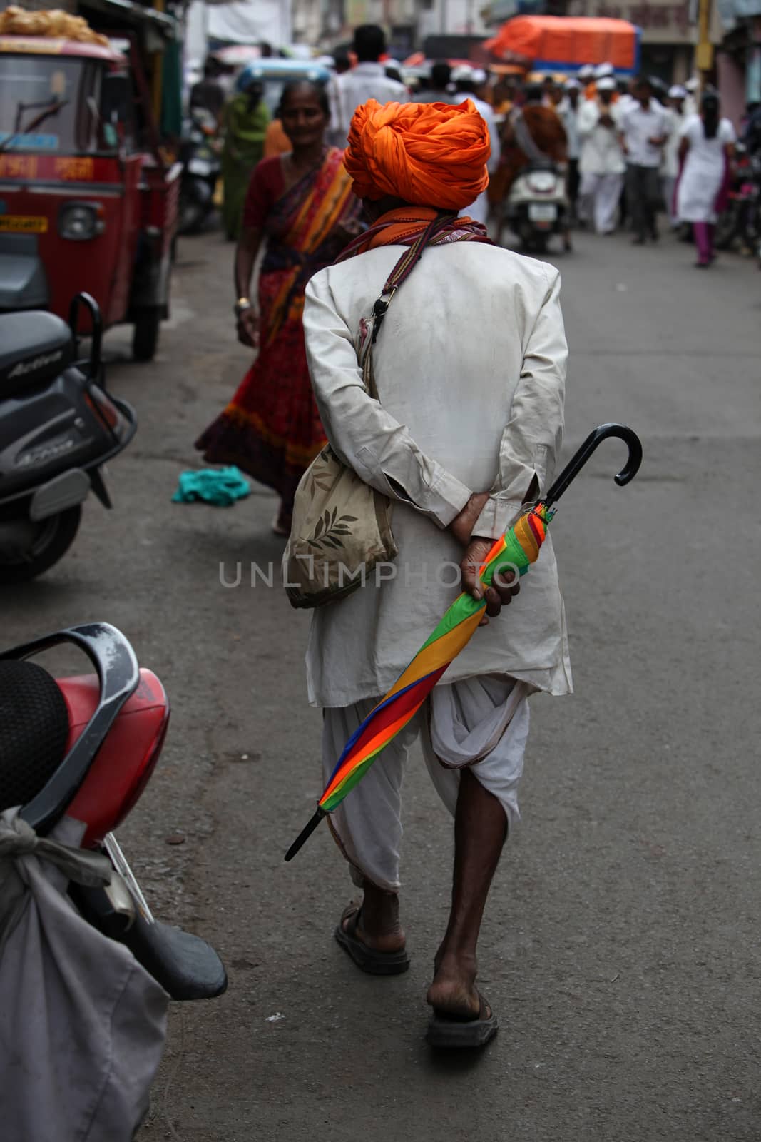 Pune, India - July 11, 2015: An old warkari walking down the road during the famous Wari festival in India.