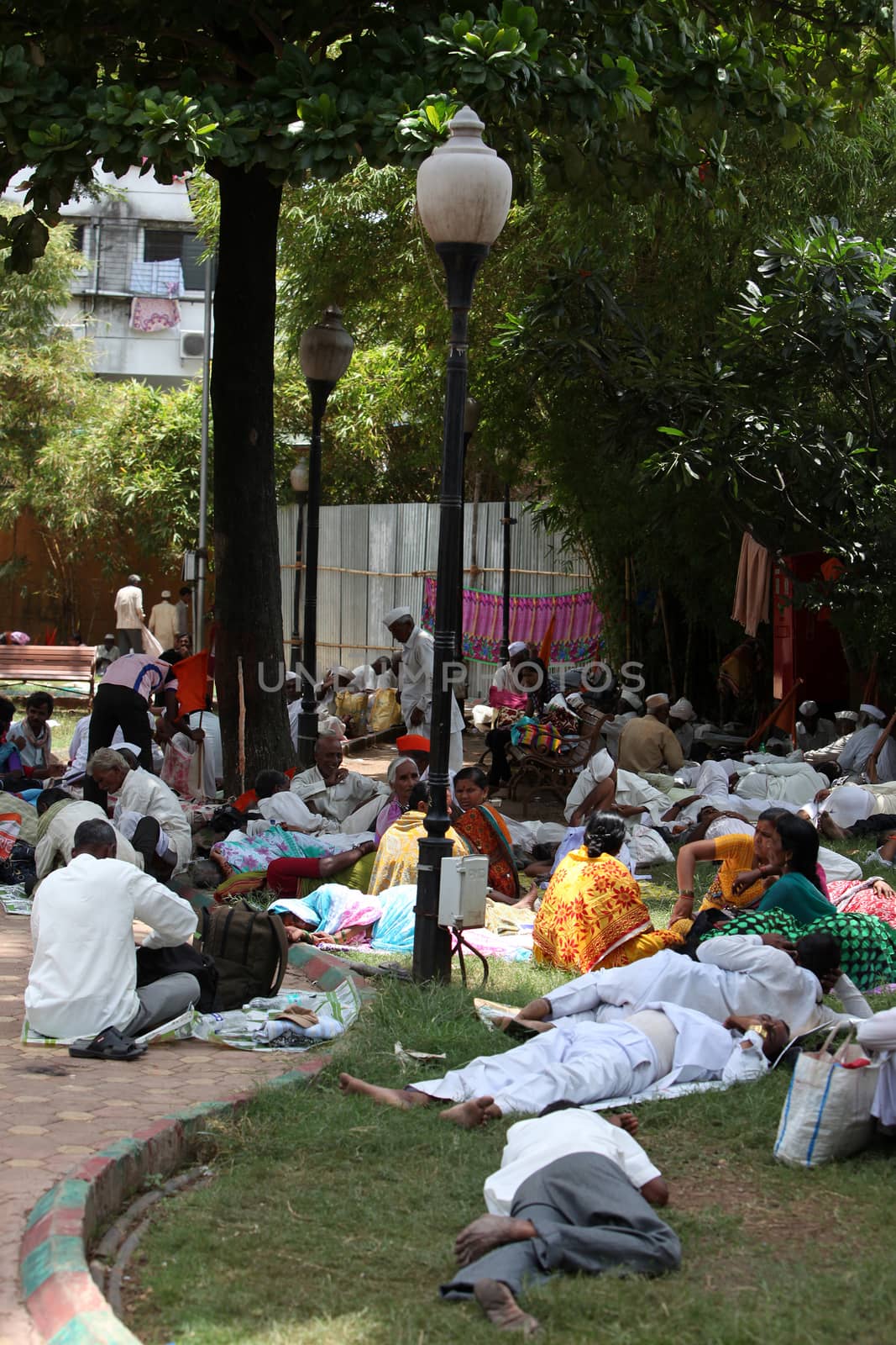 Pune, India - July 11, 2015: Indian Pilgrims called Warkaris resting in a garden during afternoon, during the famous Wari festival.