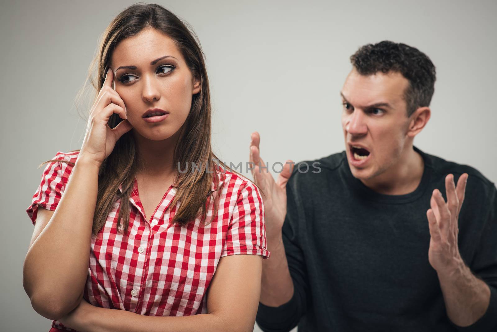 Angry aggressive husband shouting to hit his wife. Selective focus. Focus on foreground, on wife.