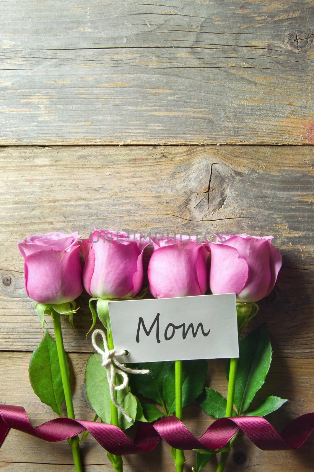 Pink  flowers on a wooden background wtih gift tag and space for text