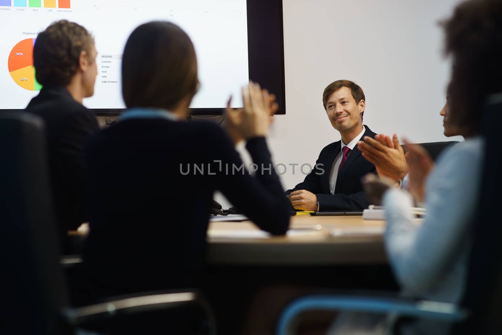 Business People Applauding Manager Doing Presentation In Meeting by diego_cervo