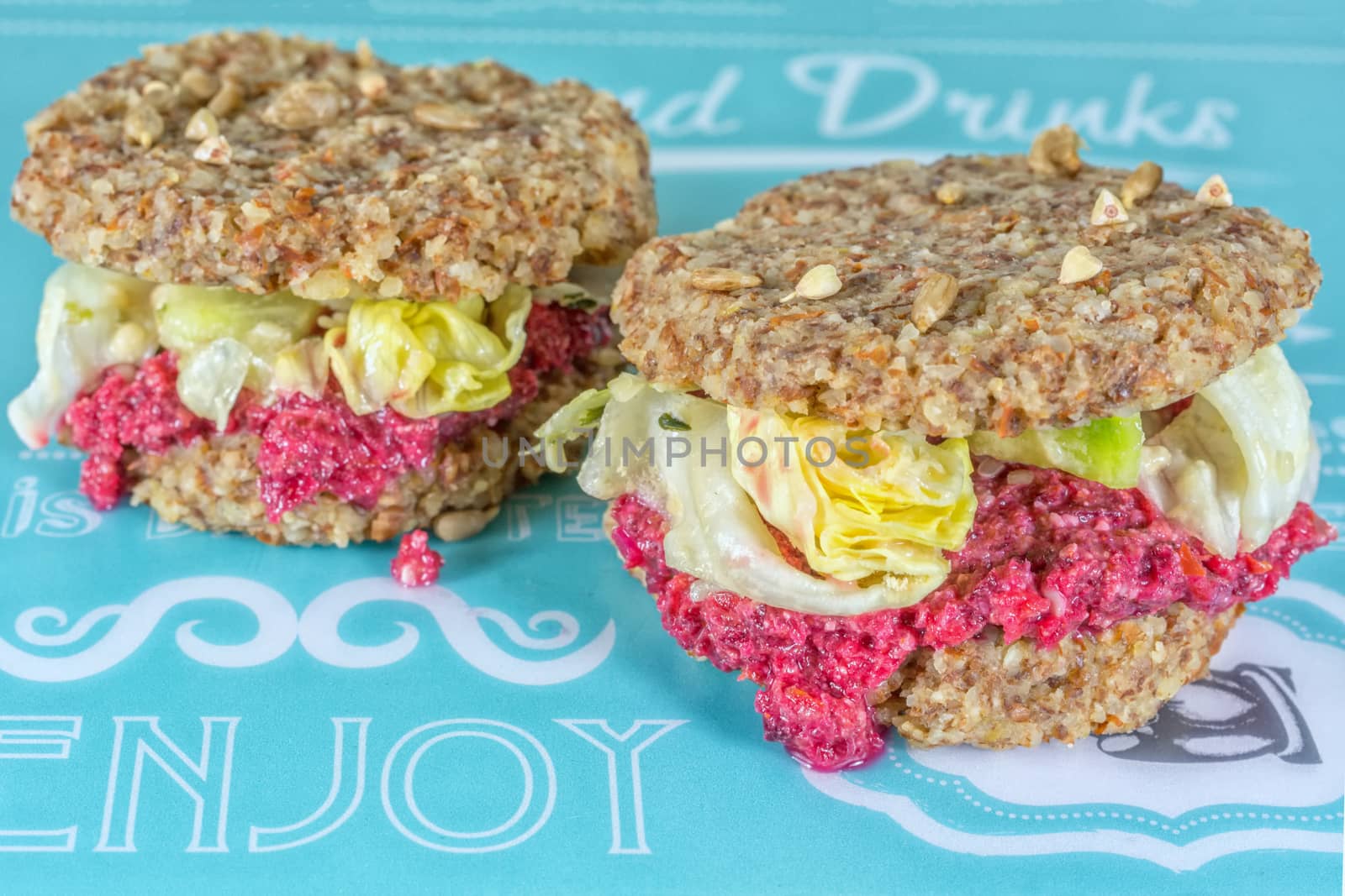 Raw burgers with beetroot and salad on a blue background