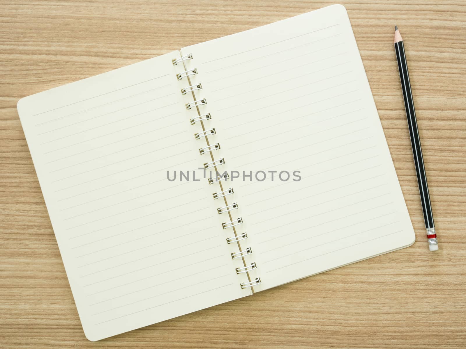 opened notebook and pencil on desk. view top