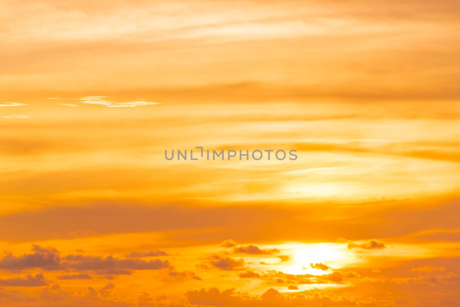 Sunset / sunrise orange sky with clouds, light rays and other atmospheric effect.