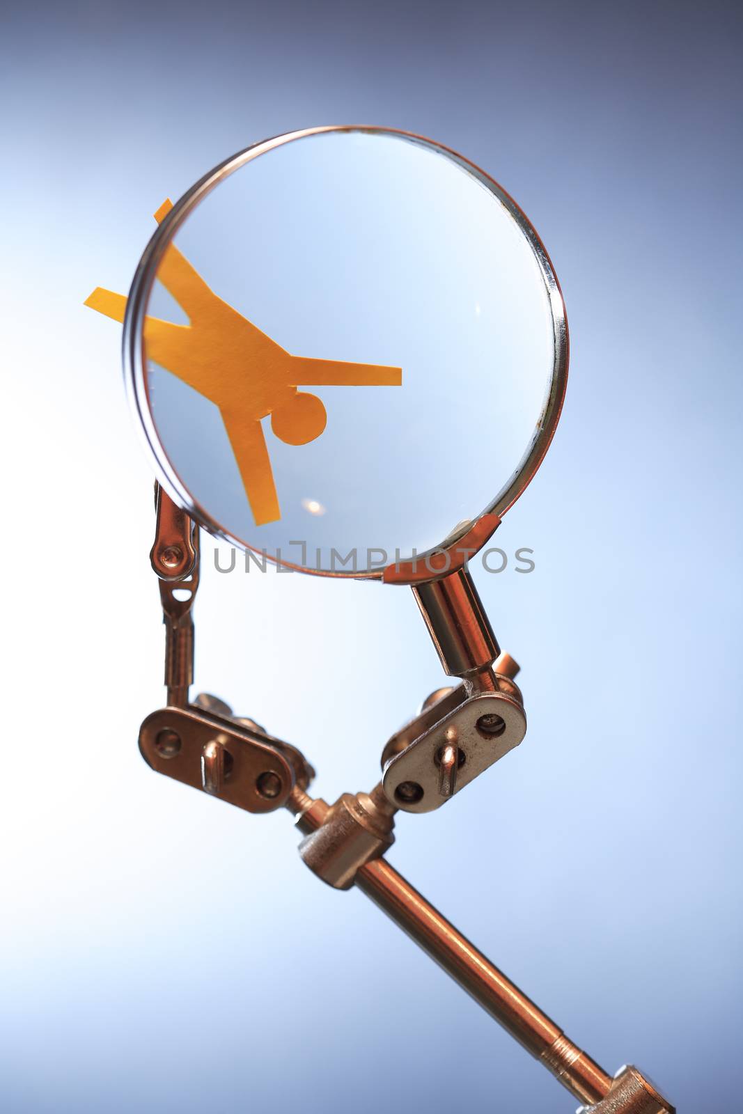 Human rights concept. Yellow paper man in metal clamping device under magnifying glass