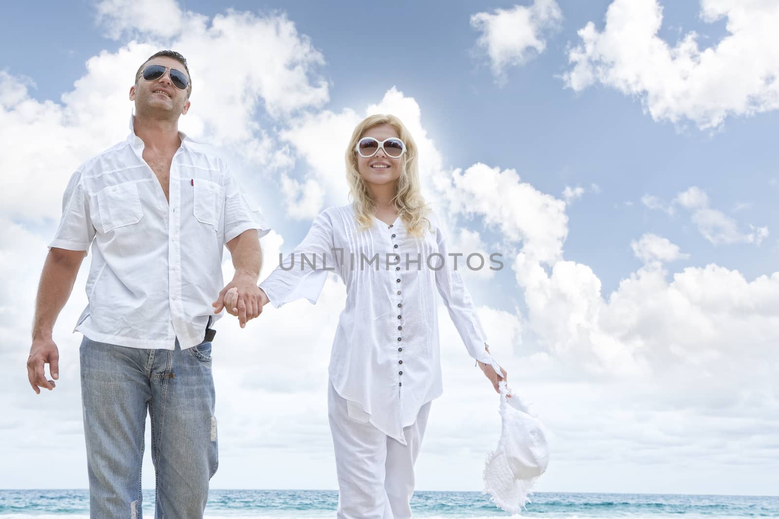Portrait of young nice couple having good time on the beach