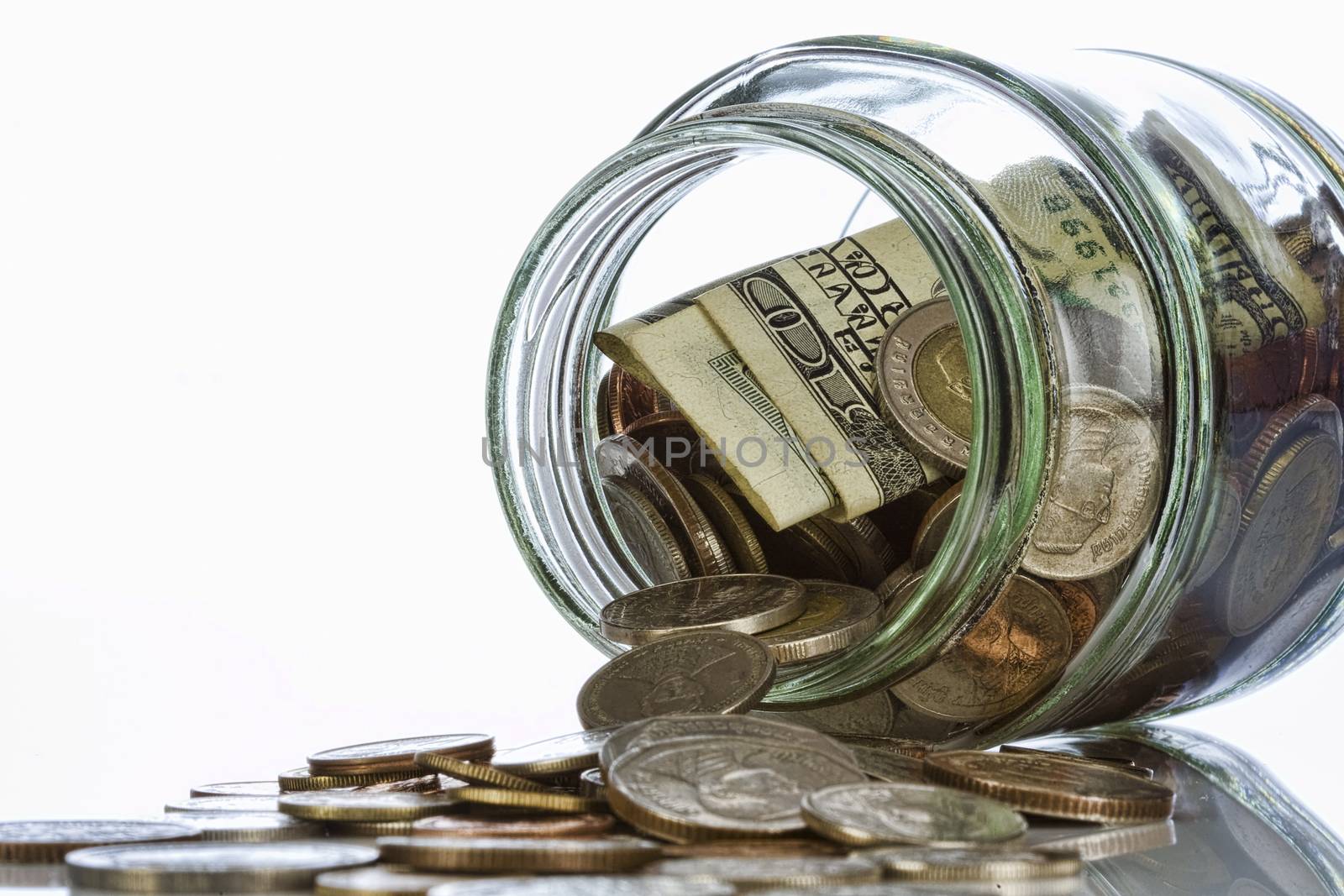 Close up view of container filled with coins on white back