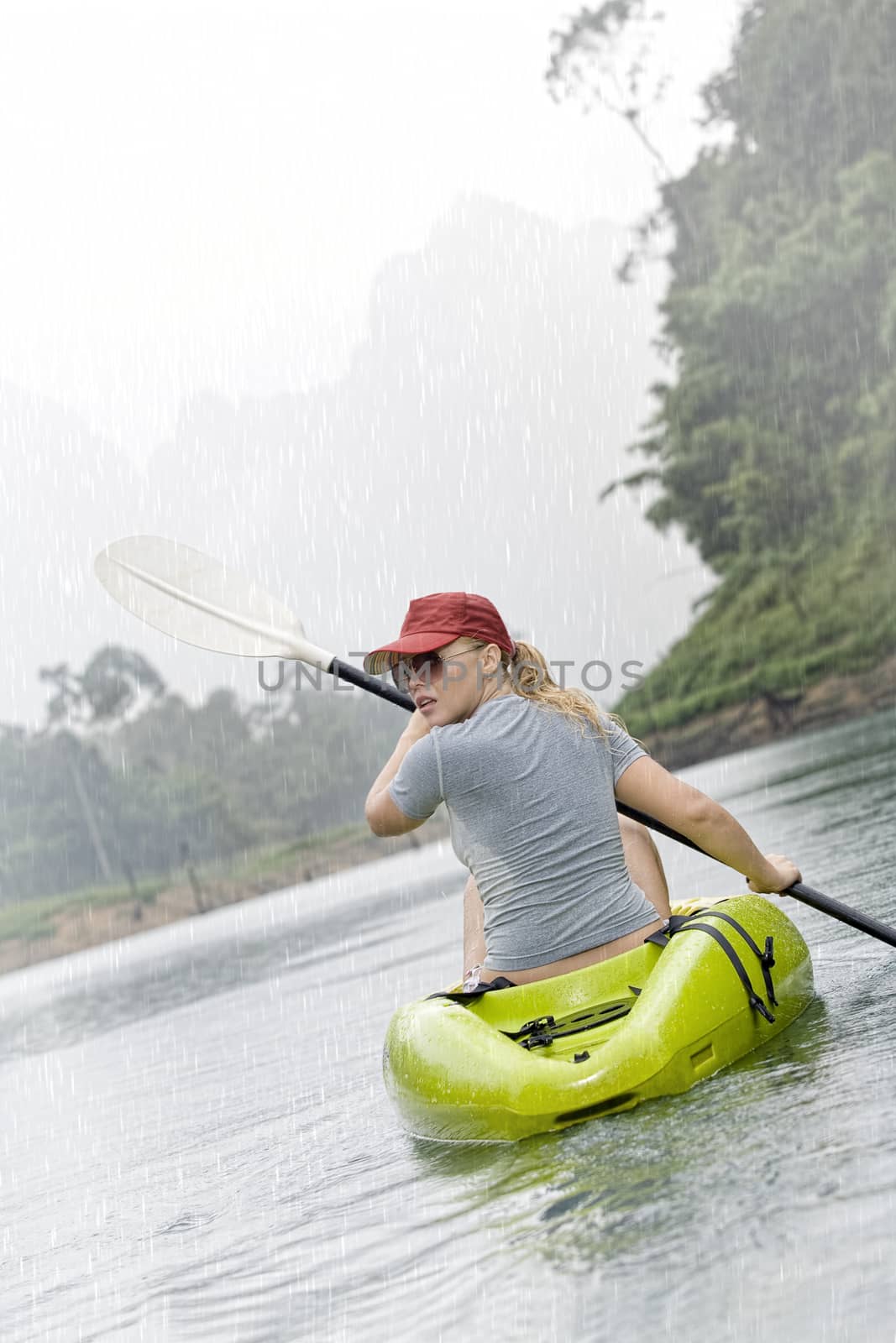 Portrait of nice young woman paddling kayak in summer  environment